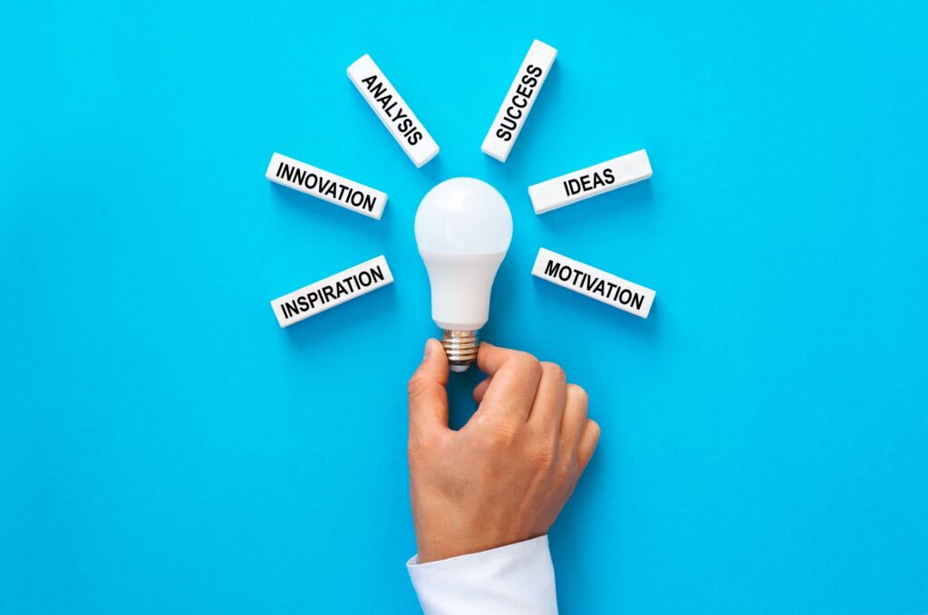 businessman-holding-light-bulb-with-wooden-blocks-2024-09-22-18-44-51-utc (1)